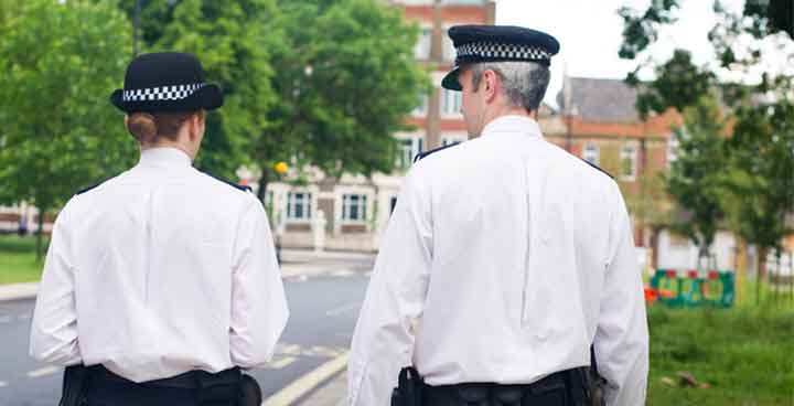 Police officers walking down the street in Clapham