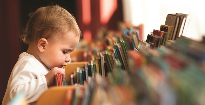 Little boy looking at books