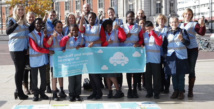 Anti-idling action days launch. Children from St. Helen’s RC Primary School stand in Windrush square holding a poster with slogan "Switch off your engine for cleaner air"