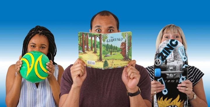 Three people, first holding ball in front of her face, second holding Gruffalo book in front of his face, third holding skateboard in front of her face.