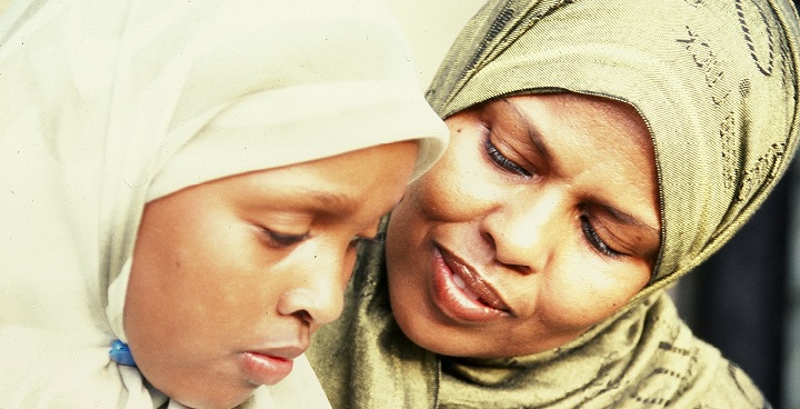 A lady and young woman, both wearing hijabs and looking down