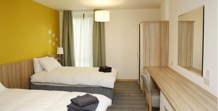 Image of a twin room in Ronald McDonald house, looking just like a hotel room with towels on the end of the beds.