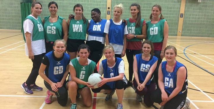 Group photo of women's netball team posed on the court.