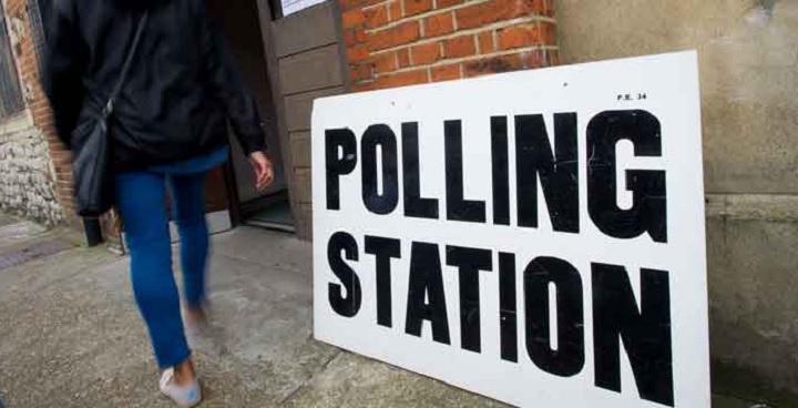 Person walking past a Polling Station sign