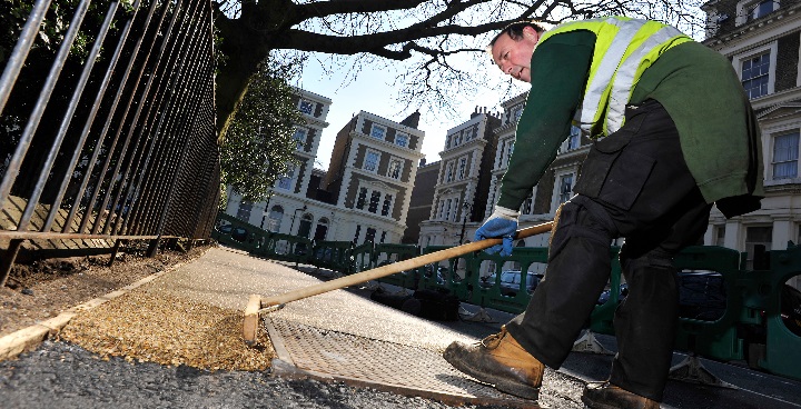 Workman resurfacing a pavement