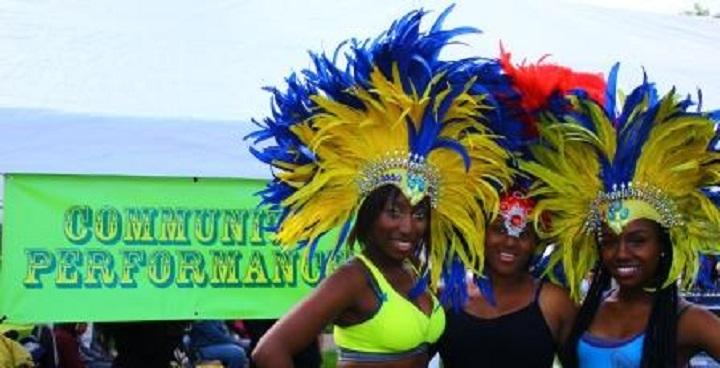 Carnival dancers with yellow and blue feather headresses at the community performance area, Stockwell Festival