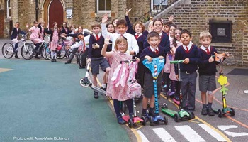 Bike parade at St Mary's Primary School, children in a wide line of bikes and scooters.