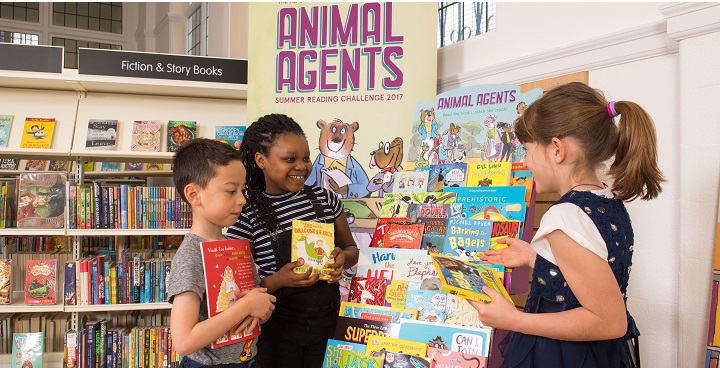 Animal Agents books on library stand and being picked up by primary school children as part of the 2017 summer reading challenge in lambeth Libraries