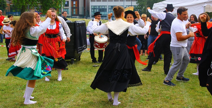 dancers in traditional costume with red sashes, black hats and white lace neckerchiefs at Stockwell Carnival 2017
