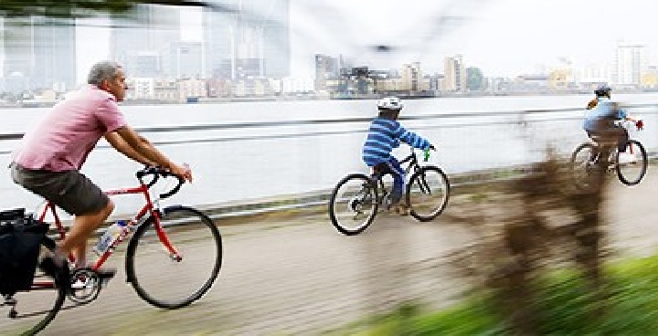 Family cycling alongside the Thames