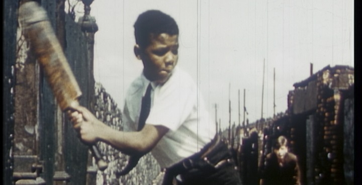 Boy playing cricket in the street - still from Black Britain on film compilation