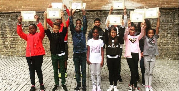 Young ultra Education graduates hold up their 'entrepreneurship training' certificates