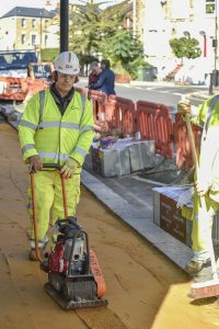 Worker Gregor Paschka levelling base for paving slabs