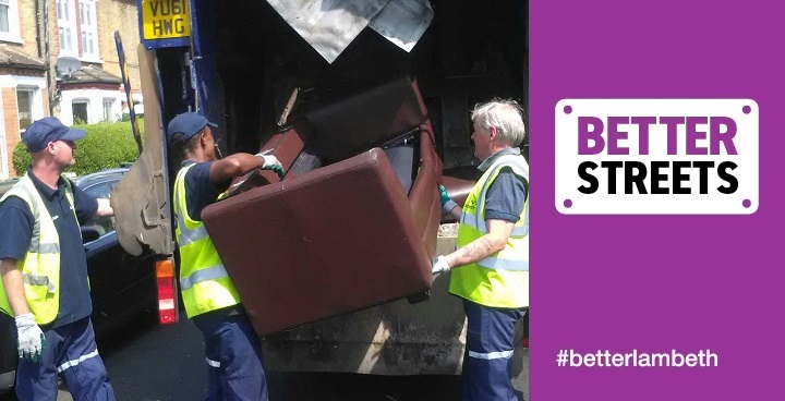 Men in hi viz tabards loading old brown sofa into collection van