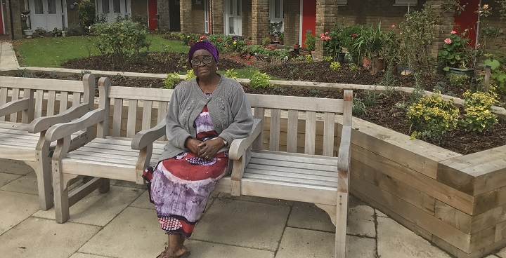Resident sat on a bench enjoying the new gardens at Balmoral Court