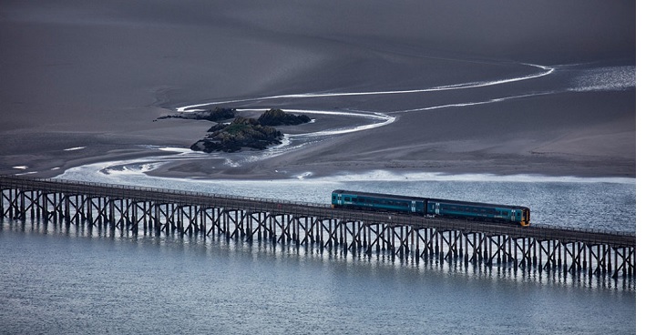 2017 winner of the Network Rail ‘Lines in the Landscape’ award. Photographed by Jon Martin, the winning image is a stunning shot of the first train crossing Barmouth bridge, Wales after sunrise.