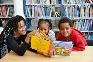 Children reading a book with an adult