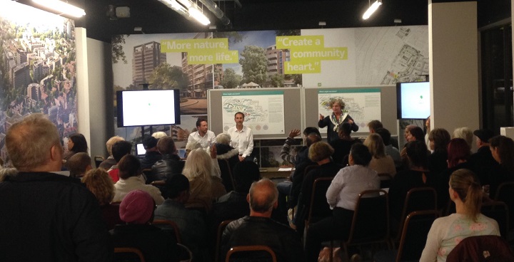 Meeting of Clapham Park Volunteer Forum with maps on wall and speakers standing in front of the audience