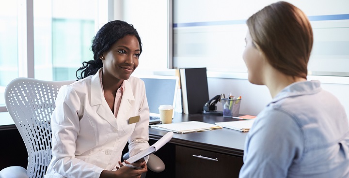 Doctor In Consultation With Female Patient In Office