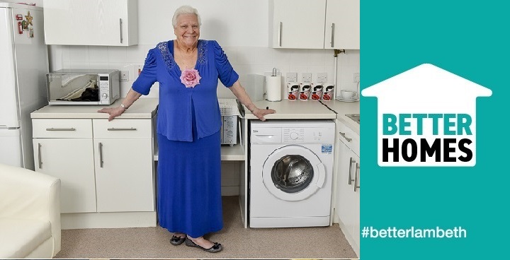 Lady standing and smiling in her new kitchen