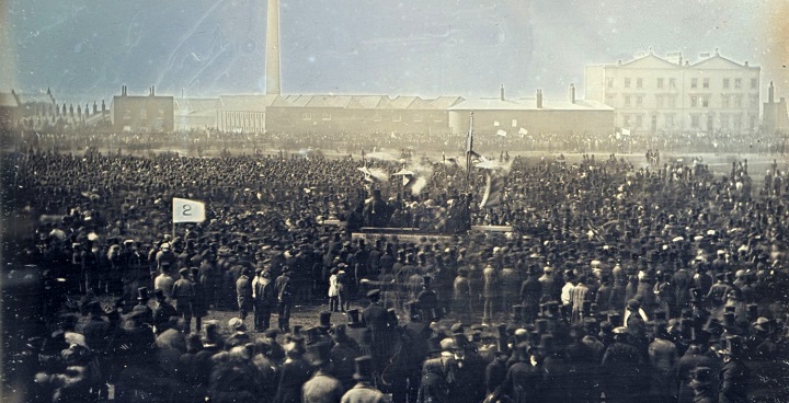 sepia tint/muted colour photo of crowd in Victorian costume on Kennington Common 1848 ready to deliver petition for right to vote to Parliament