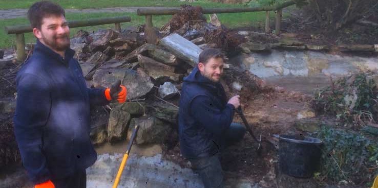 2 men in blue boiler suits working to restore the concrete pools of the Cascade water feature, Streatham Rookery