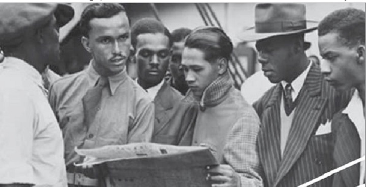 Photo of Empire Windrush passengers reading newspaper on board the ship - poster for 'Windrush Generation' event at Lambeth Town Hall 16 May 2018