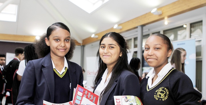 3 ethnic school girls smiling stood in a row