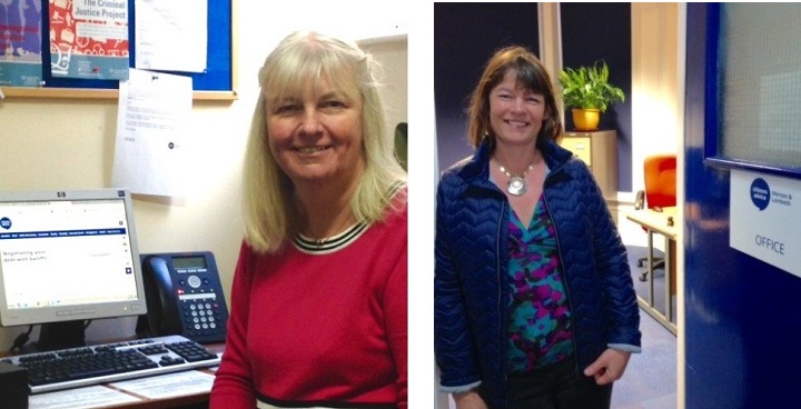 left: citizens advice volunteer Cathy (blonde hair, red jumper) sitting at a computer (right) Verena (dark hair, blue jacket & floral top)