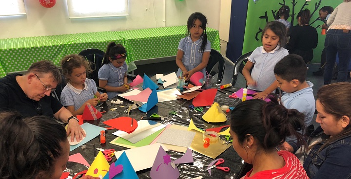 Children with coloured paper paints etc sit in a circle creating at a free Cool it Art class in Vauxhall