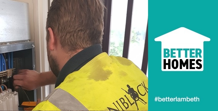 Electrician in yellow hi-viz with Niblock logo fits new junction board as part of upgrading landlord's electrics