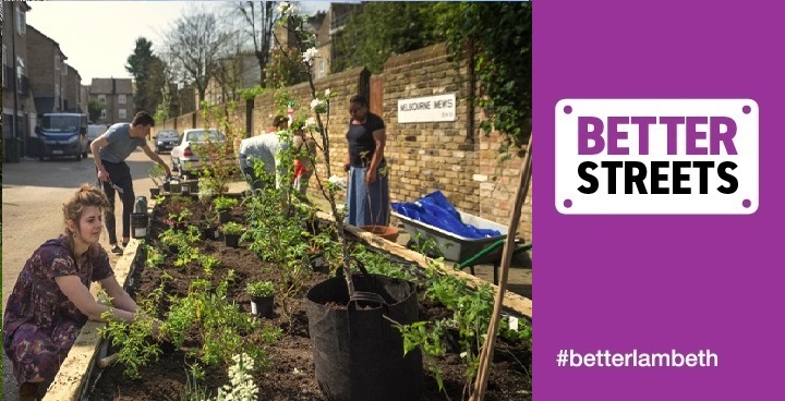 Gardeners of different ages & backgrounds planting to fill a new rfaised bed made of railway sleepers against a wall with 'Melbourne Mews' road sign