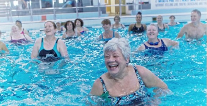 grey-haired lady in foreground of group in swimming pool