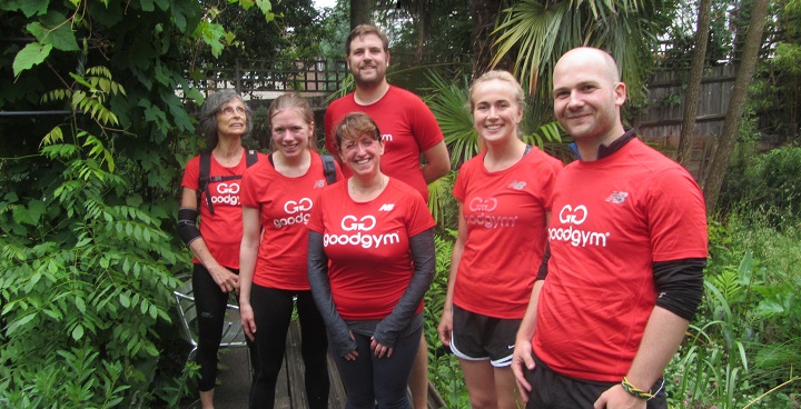 6 Good Gym runners in red kit in the gardens of South London Botanical Institute after helping move boxes of plant specimens downstairs to