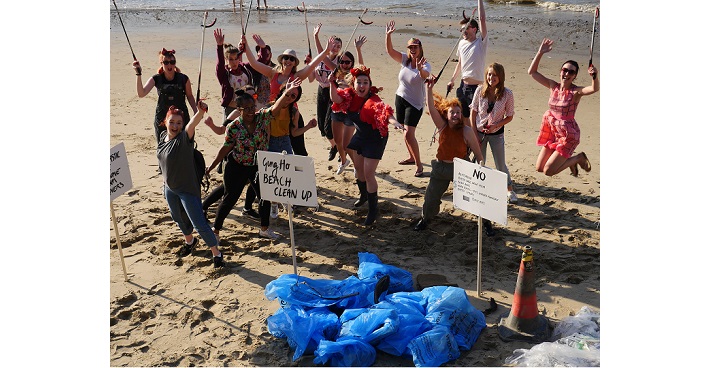 Group of young people jumping for joy on the Thames after picking up bags of rubbish - project sponsored by Veolia