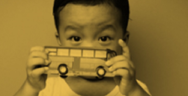 child holding toy bus in front of face - library pic from Lambeth Special Educational Needs & Disability Local Offer Web Pages