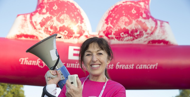 NIna Barough, CEO of walk the walk breast cancer charity at the Moonwalk on Clapham common with megaphone and background of big pink tent with big pink bra roof