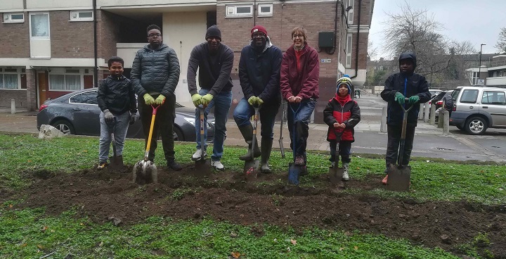 Children, parents, grandparents and representatives of food growing garden experts Urban Growth all 'dig in' for a bulb planting day