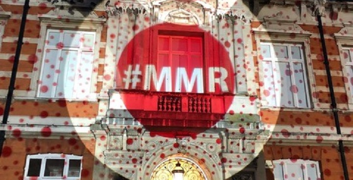 Red Measles spots projected on Brixton Library to raise awareness of need for MMR vaccination