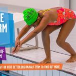 young girl (approx 8-11 in red smimsuit and green hat in 'ready to dive in' position at GLL leisure centre - advertising half term playscheme 