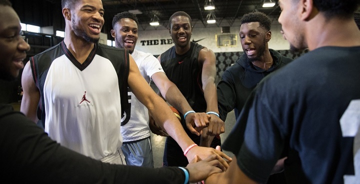 5 young men link hands at a Black Prince Trust fitness training exercise