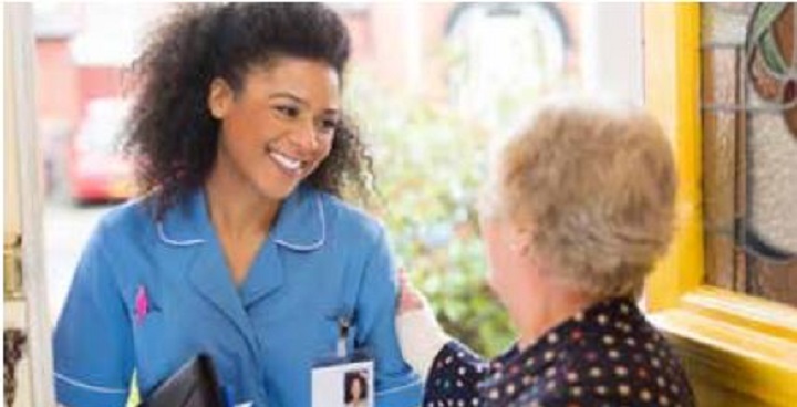 Nurse talks to elderly lady at front door