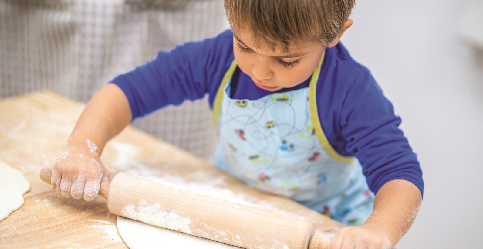 Little boy rolling dough