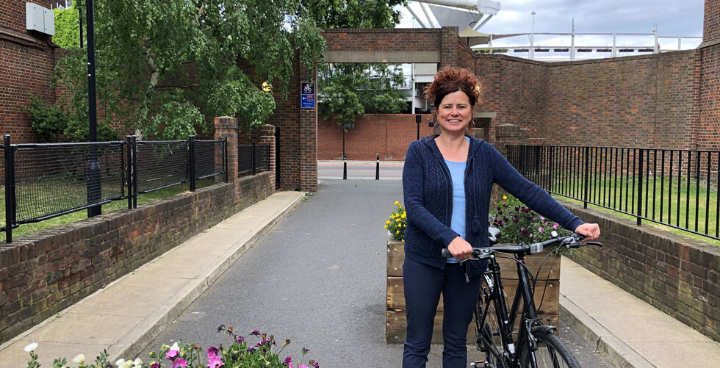 Cllr Claire Holland outdoors holding a bicycle
