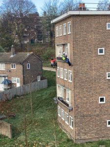 Community Fibre teams installing fibre cables by abseiling down the side of a building