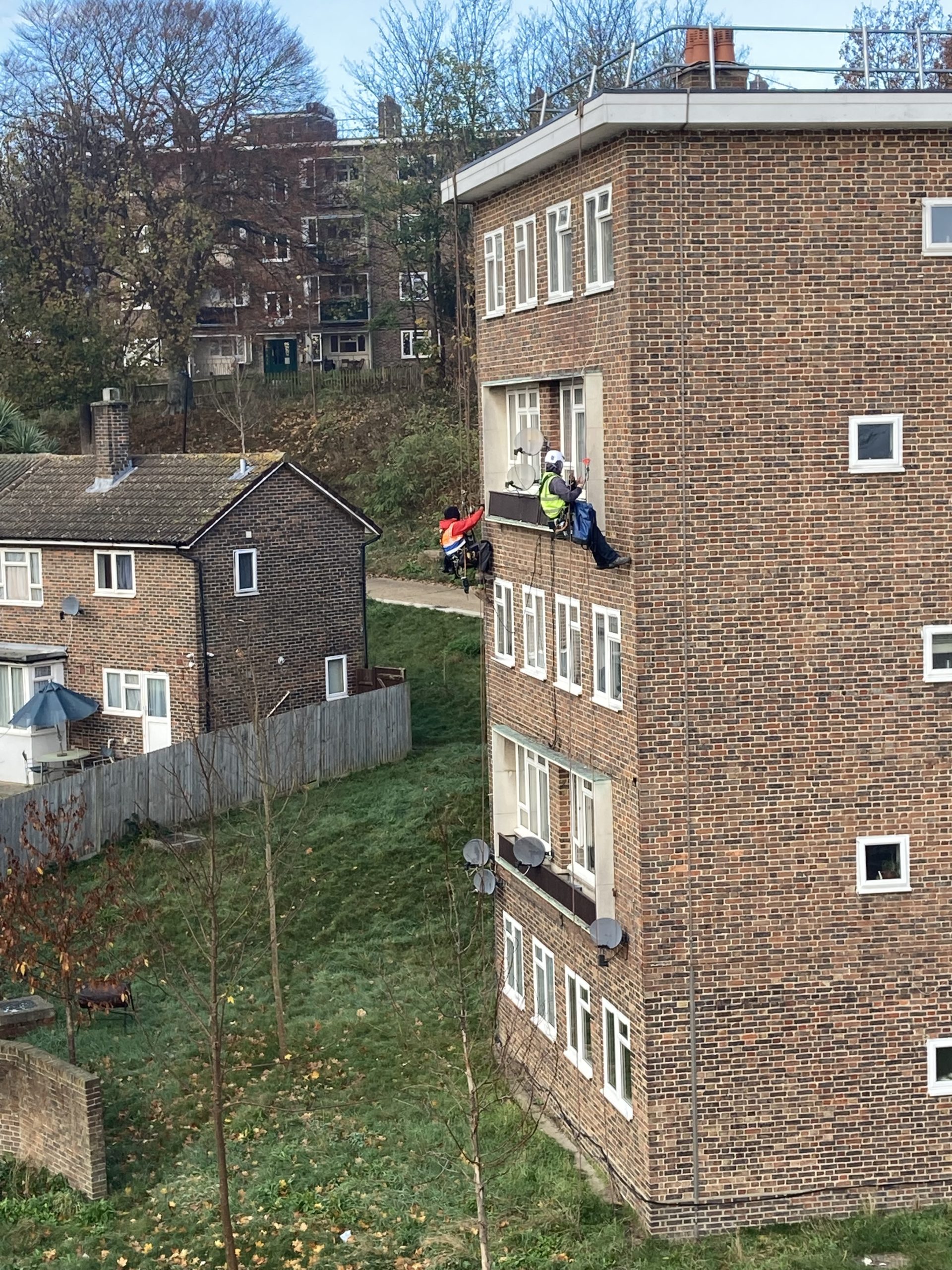 Community Fibre teams instaling fibre cables by abseiling down the side of a building