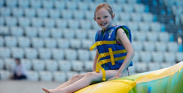 GLl betters summer 2022 girl in life jacket on inflatable slide at swimming pool