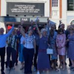 Lambeth Tour guides pose under message of congratulations over the Ritzy Cinema door