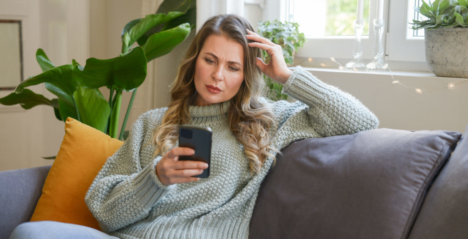 Woman sitting on a sofa looking at her phone