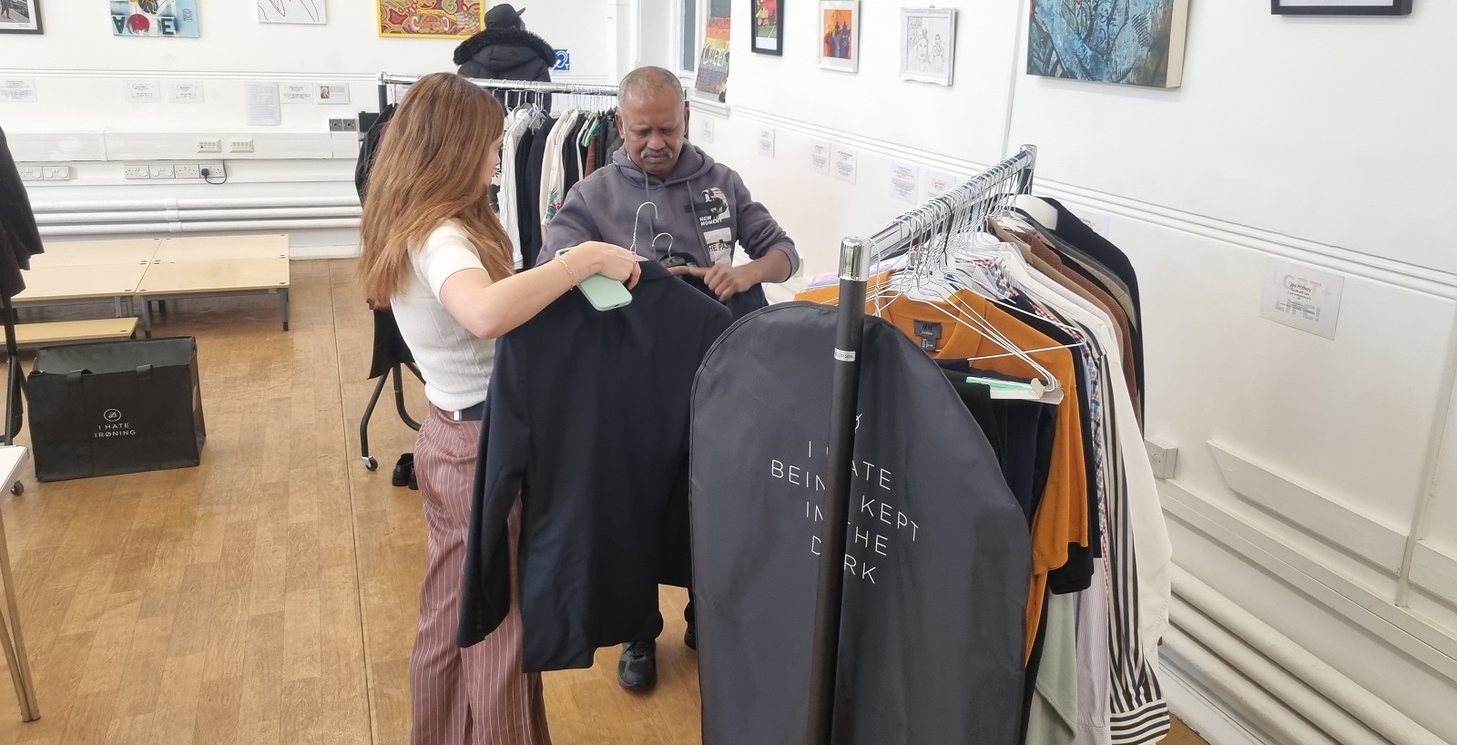 People looking at suits, shirts, blazers, etc in Brixton Library